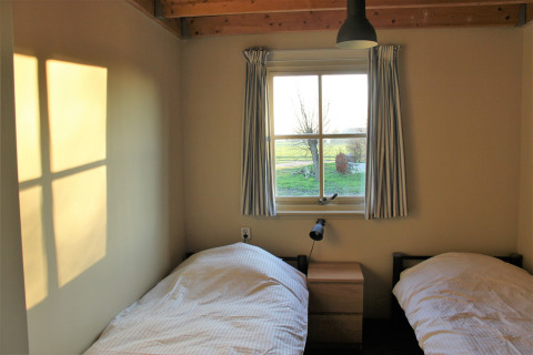 Sonnenlicht fällt durch das Fenster eines Schlafzimmers mit zwei Einzelbetten im Holiday Home 3 Aarde Green Camping Lage Zwaluwe.