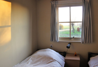 Sonniges Zimmer im Holiday Home 3 Aarde Green Camping Lage Zwaluwe mit Blick auf eine grüne Wiese in Holland.