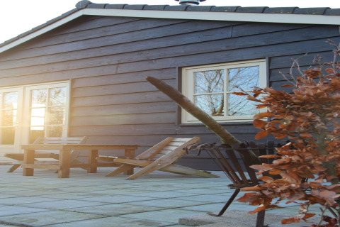 Terrasse extérieure avec chaises et table en bois au Holiday Home «3 Aarde Green Camping Lage Zwaluwe», Pays-Bas.