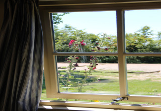 Vista da una finestra con fiori fuori al campeggio verde, Holiday Home 3 Aarde Green Camping Lage Zwaluwe.