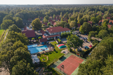 Vista aérea del parque Duc de Brabant 3 en Países Bajos con piscina, pista de tenis y chalets rodeados de bosque.