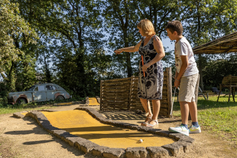 Una mujer y un niño juegan minigolf en el exterior en Park Duc de Brabant 3 en los Países Bajos.