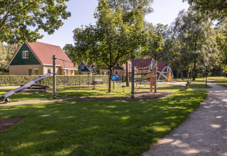 Playground at Park Duc de Brabant 3 in the Netherlands, surrounded by greenery and cozy chalets.