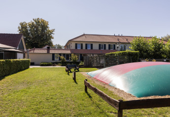 Prato con panche e grande cuscino gonfiabile vicino a chalet nel Park Duc de Brabant 3, Paesi Bassi.