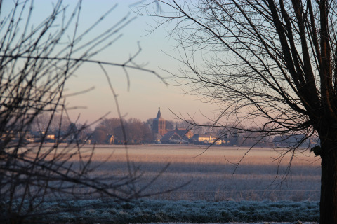 Landscape view with trees and a distant church, taken at Holiday Home 3 Aarde Green Camping Lage Zwaluwe.