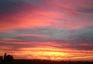 Mooie zonsondergang met levendige wolken bij Holiday Home 3 Aarde Green Camping Lage Zwaluwe in Nederland.