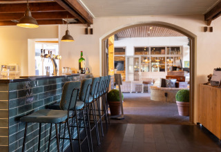 Moderne bar med høje stole og elegante lamper på Park Duc de Brabant 3 chaletten i Holland.