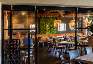 Foto del interior de un acogedor restaurante en Park 'Duc de Brabant 3', Países Bajos, con decoración verde en la pared.