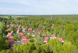 Aerial view of Park Duc de Brabant 3 chalets in the Netherlands, surrounded by trees and red roofs.