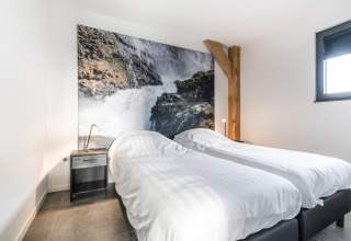 Moderne soveværelse på Park de Kievit 22-lodge i Belgien med to enkeltsenge og naturbillede på væggen.