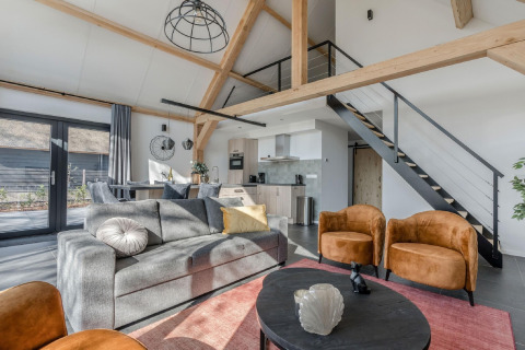 Helles, modernes Wohnzimmer im Chalet Park de Kievit 19 in Belgien mit Loft und stilvoller Einrichtung.