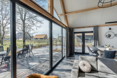 Modernes Chalet Park de Kievit 19 in Belgien mit großen Fenstern, heller Wohnbereich und Tollem Ausblick.