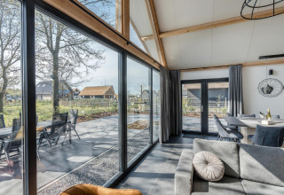 Chalet moderno Park de Kievit 19 en Bélgica con grandes ventanales, salón luminoso y vistas al exterior.