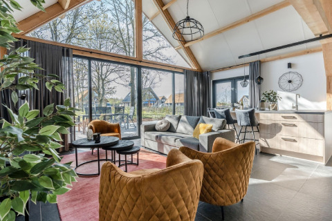 Luminoso interior de chalet en Park de Kievit 19, Bélgica, con mobiliario moderno y grandes ventanales.