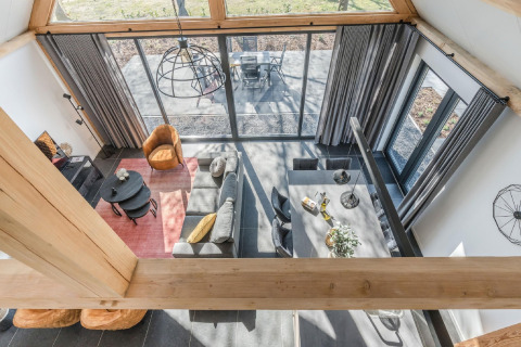 Luftaufnahme eines modernen Wohnzimmers im Chalet Park de Kievit 19, Belgien, mit großen Fenstern und stilvollen Möbeln.