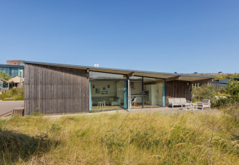 Modernes Strandhaus Sea Lodges Bloemendaal 4 mit groĂźer Glasfront und sonniger Terrasse in den DĂĽnen.