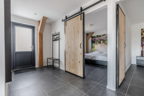Eingangsbereich im Chalet Park de Kievit 19 in Belgien mit Schiebetüren und moderner Einrichtung.