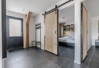 Eingangsbereich im Chalet Park de Kievit 19 in Belgien mit Schiebetüren und moderner Einrichtung.