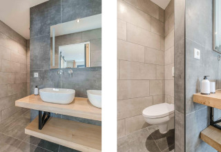 Moderne badeværelse på Park de Kievit 22 i Belgien med lyst træ, grå fliser og væghængt toilet.