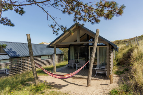 Strandhuis Sea Lodges ‘Bloemendaal 2’ in Nederland met hangmat en moderne zithoek buiten.