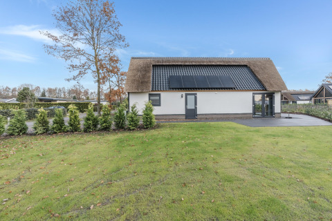 Moderne lodge i Park de Kievit 22, Belgien, med solpaneler på taget og velplejet have.