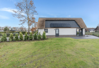 Moderne lodge i Park de Kievit 22, Belgien, med solpaneler på taget og velplejet have.