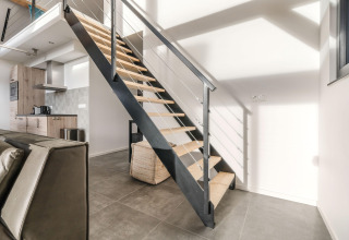 Moderne indretningsdesign i Park «de Kievit 22»-lodge i Belgien med trappe og åbent køkkenområde.