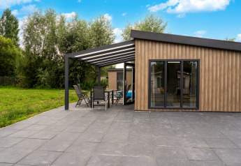 Udendørs terrasse ved Brabants Weelde 33 i Nederlandene med moderne facade og havemøbler.
