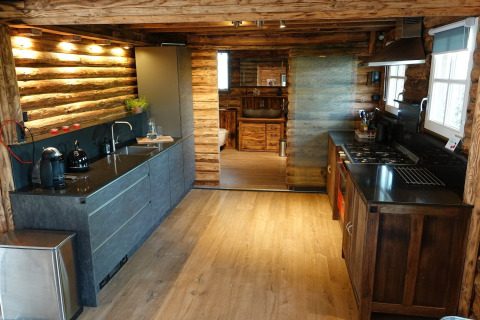 Cocina moderna en chalet de madera en Park de Kievit 11, Bélgica, con iluminación cálida y equipada.