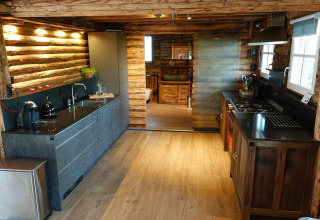 Cocina moderna en chalet de madera en Park de Kievit 11, Bélgica, con iluminación cálida y equipada.