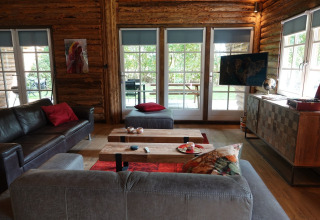 Stue i Park de Kievit 11 chalet i Belgien med moderne indretning, store vinduer og udsigt til haven.