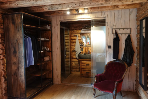 Rustikt soveværelse i Park «de Kievit 11» chalet i Belgien med træmøbler og vintage rød stol.