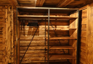 Armario de madera vacío con perchas y estantes en un chalet del Park de Kievit 11, Bélgica.