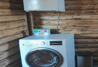 Lavadora con detergente Ariel en la parte superior, en una sala de madera en Park «de Kievit 11», Bélgica.