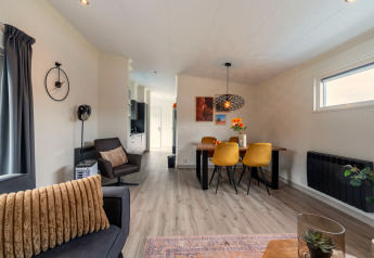 Moderne opholdsstue og spisestue i Brabants Weelde 33-lodge i Holland med gule stole og elegant interiør.