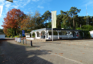 Recepción del chalet Park de Kievit 11 en Bélgica, rodeada de árboles y cielo despejado.