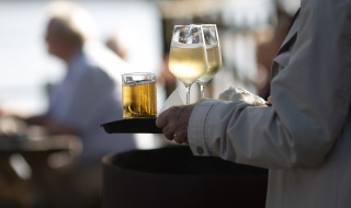 Tablett mit zwei Gläsern Weißwein und anderem Getränk
