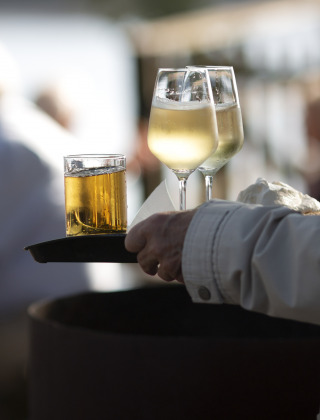 Tray with two glasses of white wine and other drink