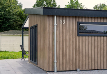 Moderne lodge med træbeklædning og store vinduer, nummer 33, taget ved Brabants Weelde i Holland.