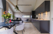 Sala de estar y cocina modernas en Holiday Park Latour 4 en los Países Bajos, con decoración elegante.