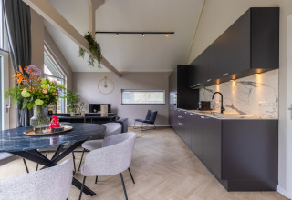 Modern living room and kitchen in Holiday Park Latour 4, Netherlands, with sleek decor and natural light.