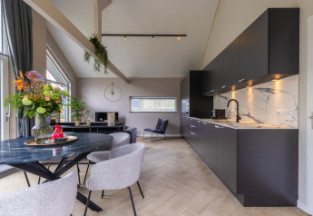 Sala de estar y cocina modernas en Holiday Park Latour 4 en los Países Bajos, con decoración elegante.
