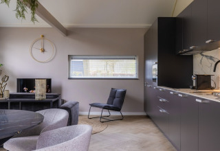 Modern living room and kitchen at Holiday Park «Latour 4» in the Netherlands with sleek contemporary decor.