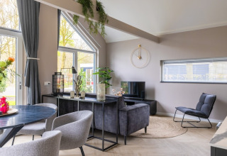 Salon moderne au Holiday Park «Latour 4» aux Pays-Bas, décoré avec goût, grandes fenêtres et mobilier élégant.
