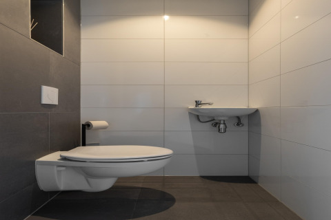Modern minimalist bathroom with wall-mounted toilet and small sink at Holiday Park Latour 4, Netherlands.