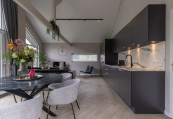 Alojamiento moderno en Holiday Park «Latour 6», Países Bajos, con cocina negra y zona de comedor elegante.