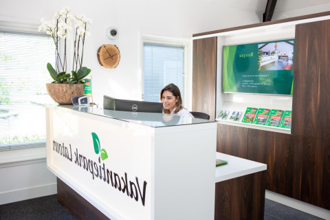 Receptionist working at the front desk of Holiday Park Latour 8 lodge in the Netherlands with modern decor.