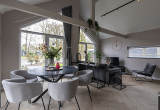 Moderne lodge-interieur met grote ramen en stijlvolle meubels in Holiday Park Latour 6, Nederland.