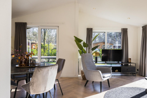 Lichte, moderne lodgewoonkamer in Holiday Park Latour 8, Nederland, met grote ramen en stijlvolle inrichting.