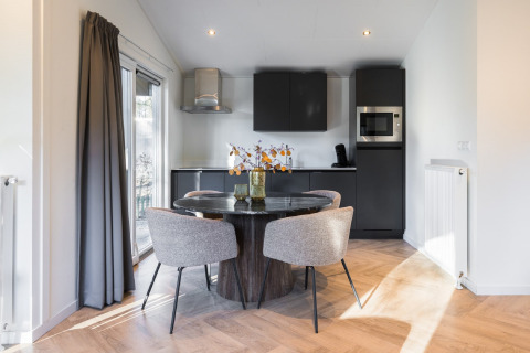 Modern dining and kitchen area at Holiday Park «Latour 8» in the Netherlands with stylish black decor.